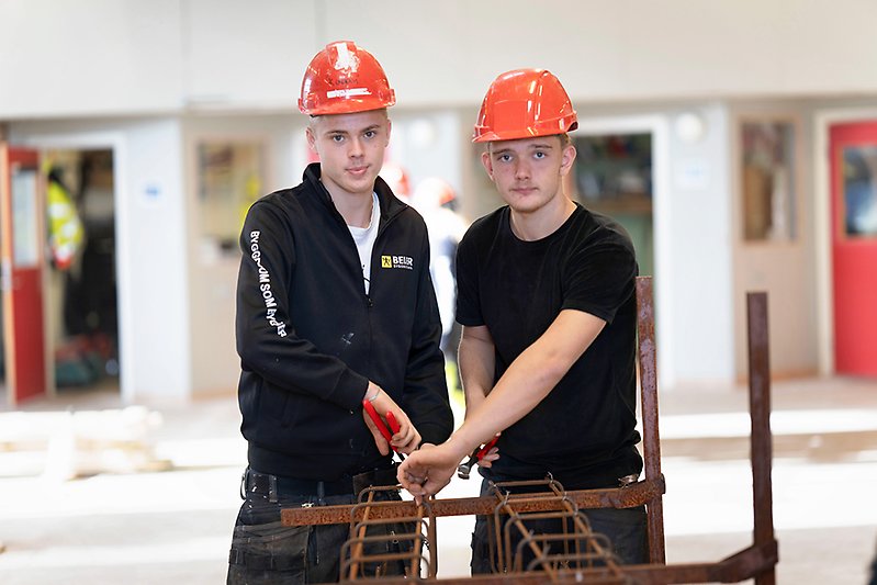 Två elever som står vid en kapsåg