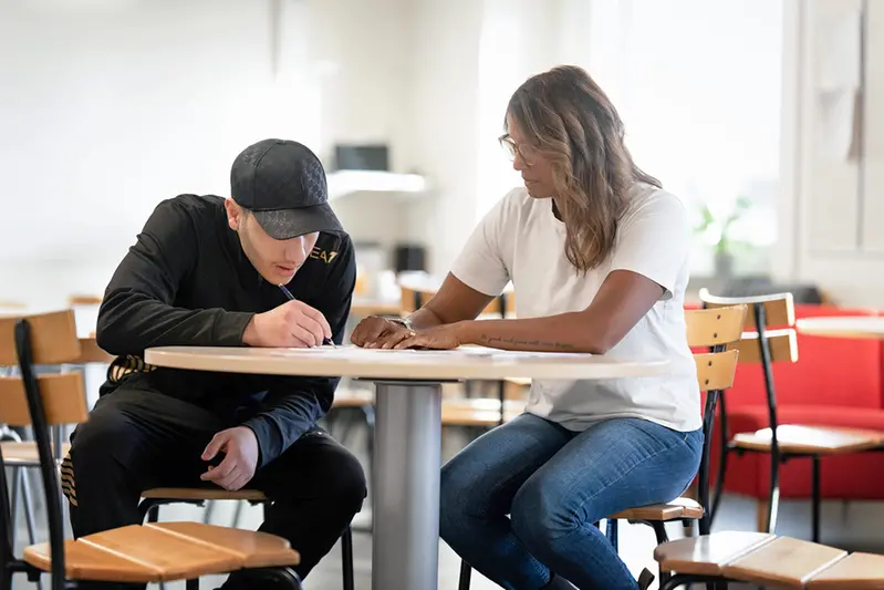 en elev som får hjälp av personal att plugga