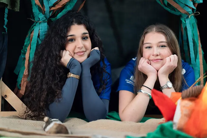 Två elever som går utanför skolan. Glada