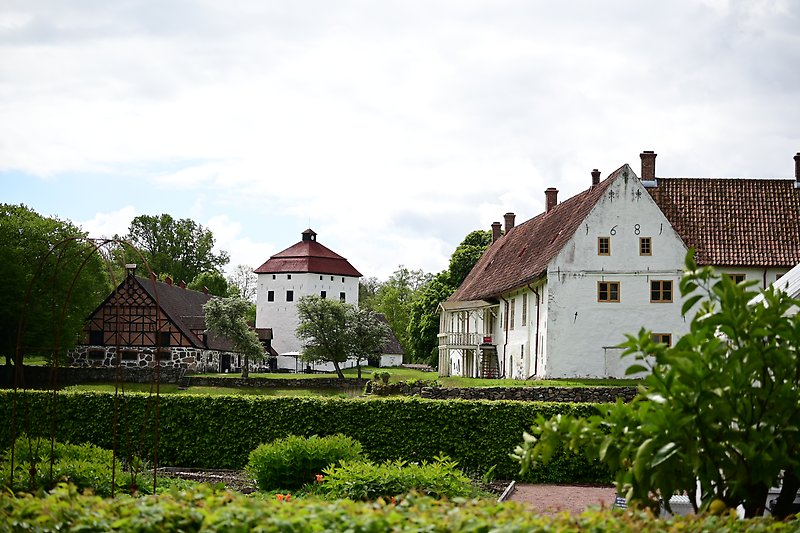Sommarbild från Hovdala slott som visar slottsbyggnaderna från slottsträdgården sett. 