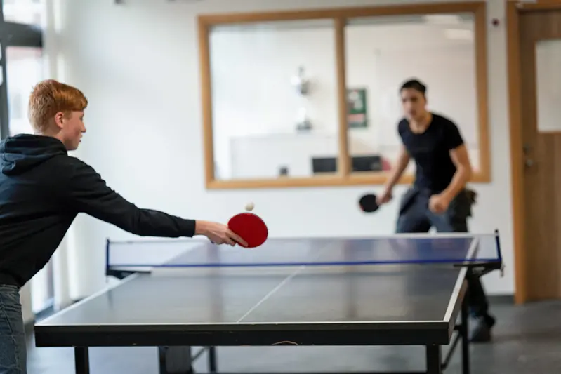 två elever som spelar pingis