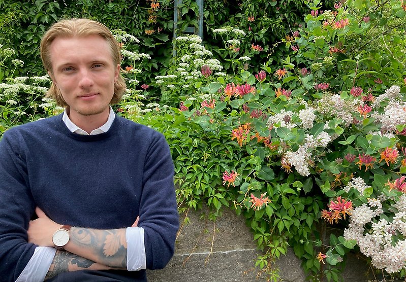 Byggnadsinspektör Noah Olsson framför en rabatt med mur.